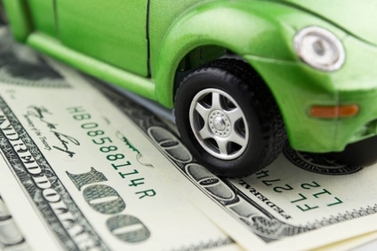 green toy car parked on a dollar bill
