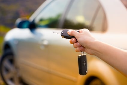 women's hand presses on the remote control car alarm