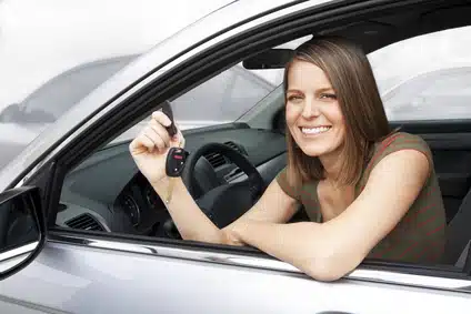 woman holding a key car inside her car
