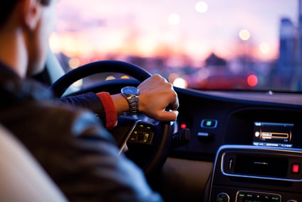 Man driving his modern car at night in a city